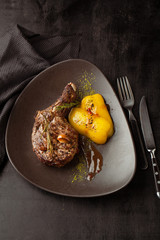 Grilled beef bone with sauce and baked vegetables on a plate