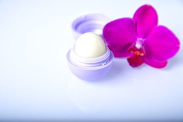 Lip balm with flower on white background