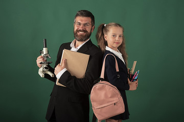 Man in suit and girl with bag wears uniform
