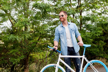 Handsome man enjoying with his bike in the park