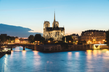 Notre dame de paris cathedral with Seine river at night in Paris, France.