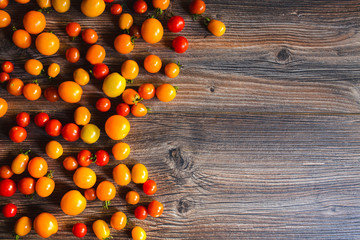 Fototapeta na wymiar A lot of red and yellow mini tomatoes on the table. Background.