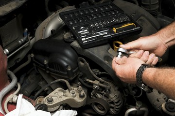 The mechanic fixes the vehicle's engine