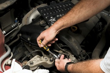 The mechanic fixes the vehicle's engine