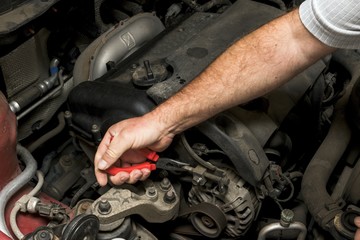 The mechanic fixes the vehicle's engine