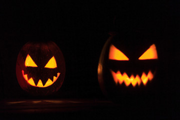 two pumpkin heads burn in the night