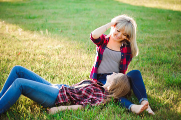 Two happy female friends playing and having fun in green grass