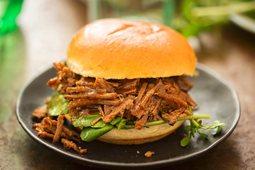 Sweet bun barbecue beef brisket with watercress leaves. Whisky barrel chip smoked British beef brisket with smoky barbecue sauce