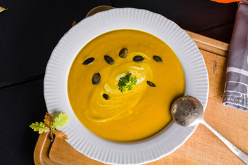 Autumn background scene of pumpkin soup with pumpkin seeds.