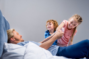 father with kids in bed