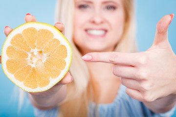 Woman pointing on grapefruit citrus fruit