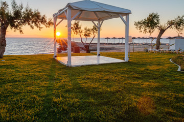 White wooden shed at seashore during sunrise.
