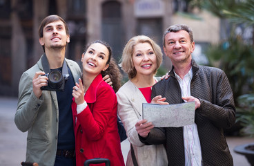 Portrait of tourists with map and baggage seeing the sights in European city