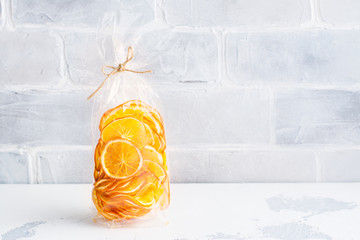 Sunny orange slices in a cellophane bag. Edible present. Copy space - obrazy, fototapety, plakaty