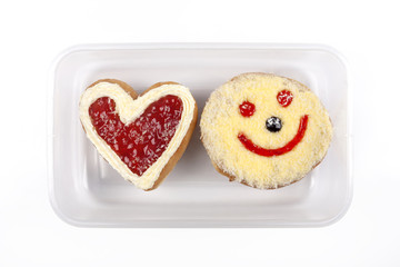 Heart shaped and smile donut in plastic box on white
