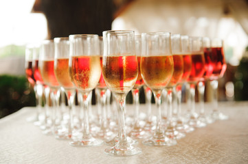 A lot of wine glasses with a cool delicious champagne or white wine at the bar. Alcohol background.