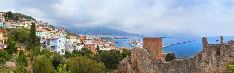 Fototapeta premium Panoramic view of Alanya harbor and ancient stone wall of Alanya Castle. Alanya, Turkey