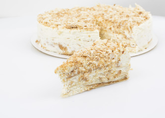 Piece of cake on the background of a whole cake
