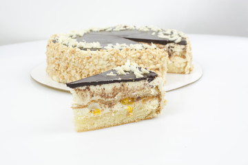 Piece of cake on the background of a whole cake