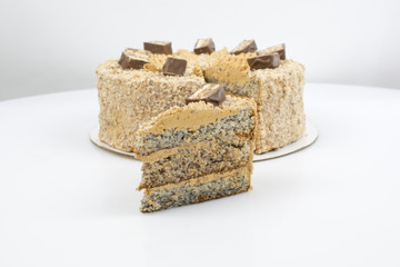 Piece of cake on the background of a whole cake