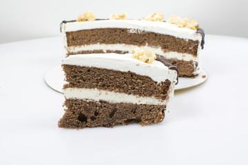Piece of cake on the background of a whole cake