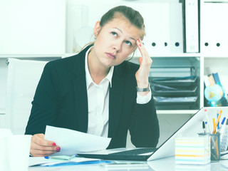 Young female in black suit is having complicated issue with project