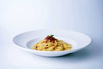 spaghetti carbonara on white plate with bacon ,white background 