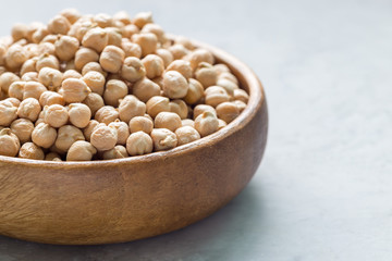 Uncooked dry chickpeas in wooden bowl, horizontal, copy space