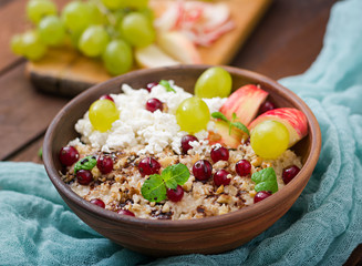Fototapeta na wymiar Delicious and healthy oatmeal with grapes, nuts, apples and cottage cheese. Healthy breakfast. Fitness food. Proper nutrition