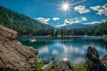 Mountain lake and dark green coniferous forest  in Switzerland before sunset