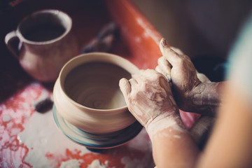 Work in a pottery workshop, womans hands creating ceramics. 