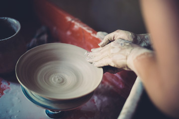 Work in a pottery workshop, womans hands creating ceramics. 