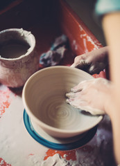 Fototapeta na wymiar Work in a pottery workshop, womans hands creating ceramics. 
