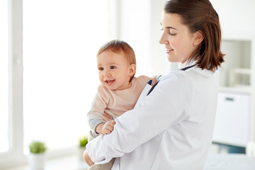 doctor or pediatrician holding baby at clinic