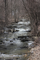 Scenic little waterfall flowing down and over a tier of rocks, due to spring thaw runoff.

