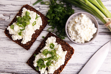 Cream Cheese on a slice of bread topped with fresh green onions or spring onions