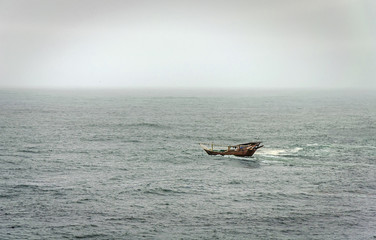 A lonely fishing boat on the big waves at the Indian Ocean