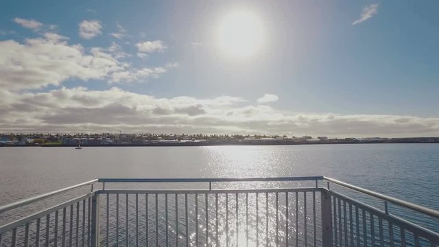 moving shot on a wooden pier, showing panorama of Reykjavik from city beach