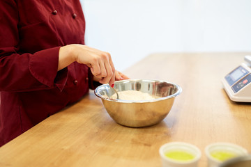 chef with flour in bowl making batter or dough