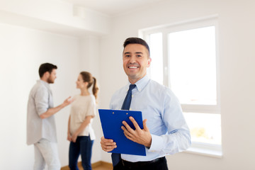realtor with clipboard and couple at new home