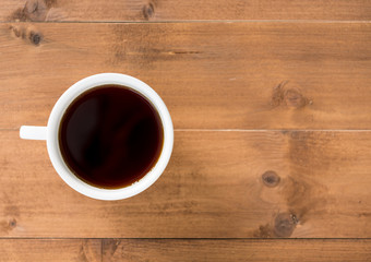 Black coffee in white cup on brown wooden background