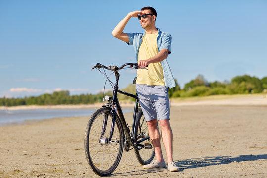 happy man with bicycle on summer beach