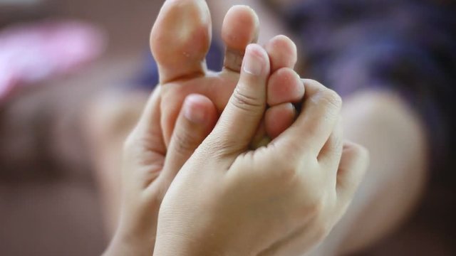 Hands of young woman gently touch massage to foot of old women metaphor and concept for body health care and therapy  of family old mother and young daughter