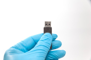 hand in blue glove holding flash drive