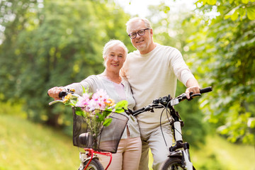 happy senior couple with bicycles at summer park - obrazy, fototapety, plakaty