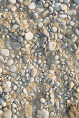 Closeup of pebble stones texture on a sunny day