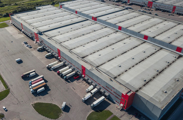 Aerial view of trucks loading at logistic center - obrazy, fototapety, plakaty