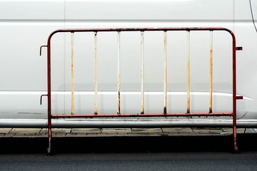 Steel traffic barrier on wheel front a white car