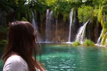 Fototapeta premium close up on beautiful woman looks on waterfall in forest 