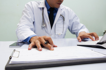 Medicine doctor in white gown working with digital tablet at table  in the hospital